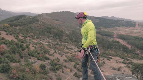 climber throws rope from a cliff