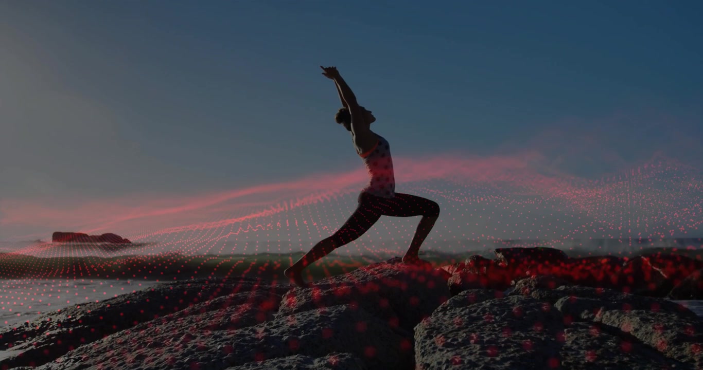 Donna che pratica yoga su scogli oceanici con sovrapposizione digitale futuristica