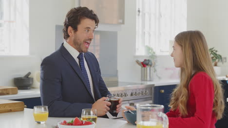 Father-Wearing-Suit-Having-Breakfast-With-Teenage-Daughter-In-School-Uniform-At-Home-In-Kitchen