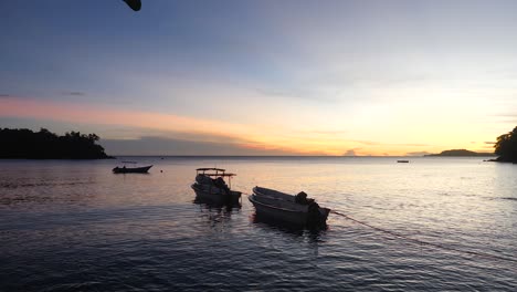 Sky-colours-background,-wooden-boats-moored,-silhouette-idyllic-scenery