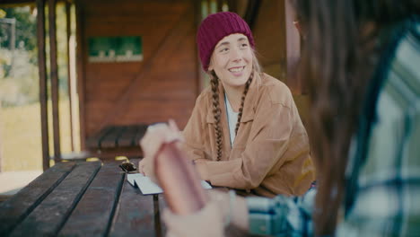 Woman-Discussing-With-Friend-Sitting-At-Table