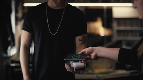 caucasian man taking a pay in tattoo studio.