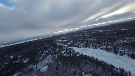 cloudy aerial view of frozen siesta lake surrounded by forests. quebec, canada