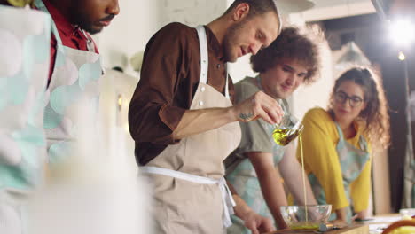 chef using olive oil and speaking with people at cooking class