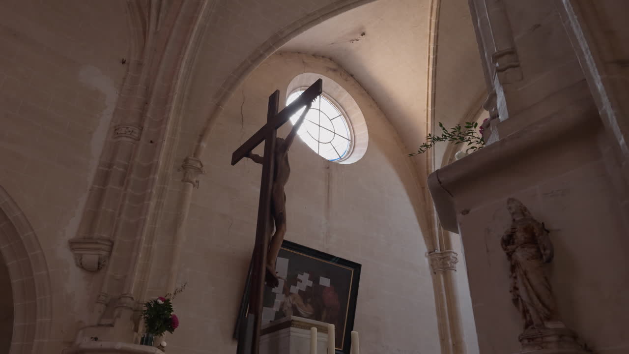View of circular window above prominent crucifix Jesus inside Church of Saint-Fargeau, in France