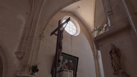 view of circular window above prominent crucifix jesus inside church of saint-fargeau, in france