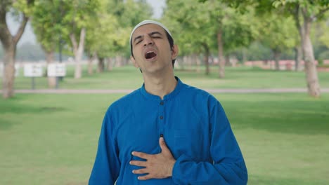 sick muslim man having an asthma attack in park