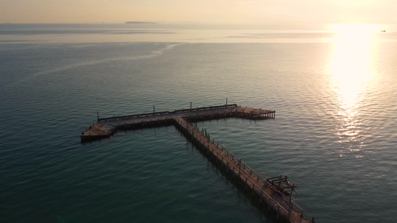 Aerial View of a Wooden Pier at Sunset Over the Ocean
