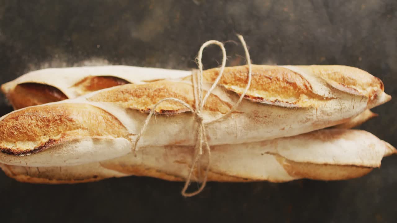 Video di baguette legate con un nastro su superficie nera.
