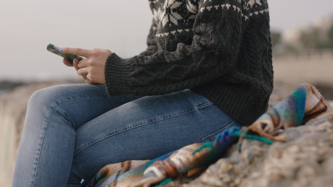 manos de una mujer usando un teléfono inteligente escribiendo mensajes de texto navegando en línea en las redes sociales disfrutando de sentarse en la playa relajándose