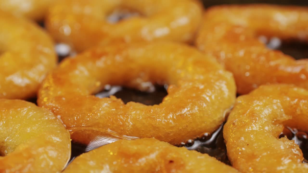 Fried crispy onion rings in a frying pan with oil close-up macro. Roasted onion rings for snacks at bar, cafe. Fast food. Delivery. Beer snacks