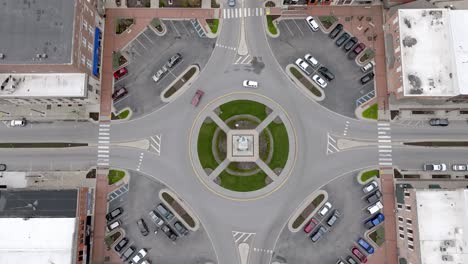 Angola,-Indiana-town-square-roundabout-with-cars-moving-around-and-stable-drone-video