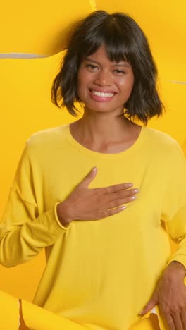 a woman radiates joy in a bright yellow outfit showcasing a heartfelt gesture