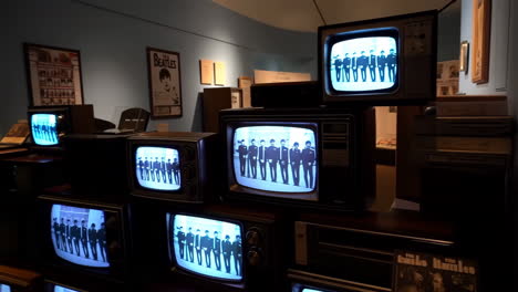 vintage televisions displaying the beatles in a museum exhibition