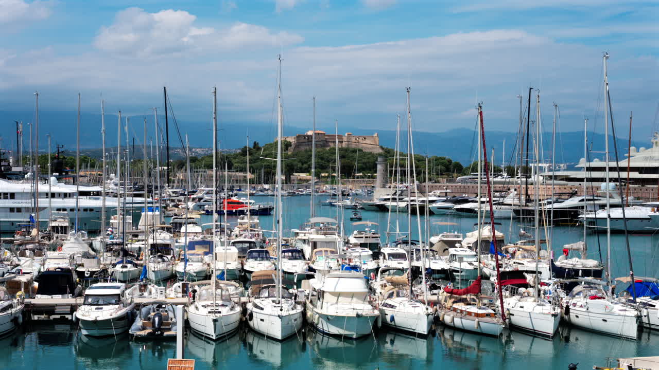 Boats docked in the Port Vauban with the Fort Carre on the background in Antibes, France