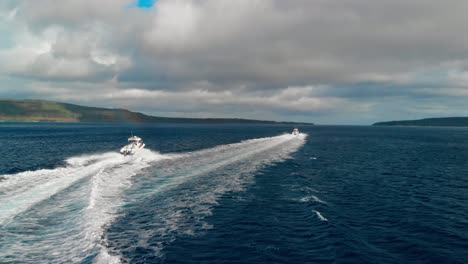 dramatic aerial view on two speedboats sailing in tropical sea by exotic island