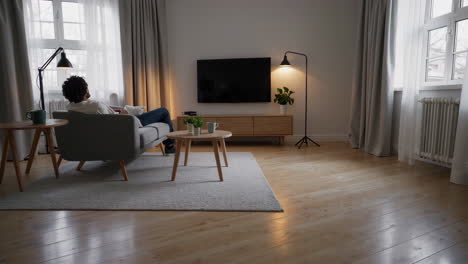 person relaxing on a sofa in a modern living room