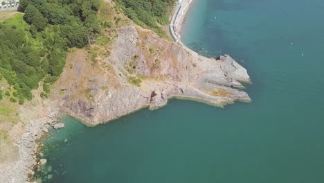 aerial over head of cliffside, beside a beautiful bay