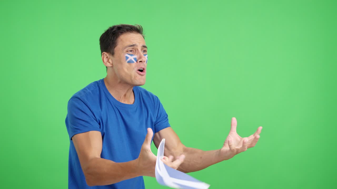 Nervous man cheering for Scotland during a match looking away