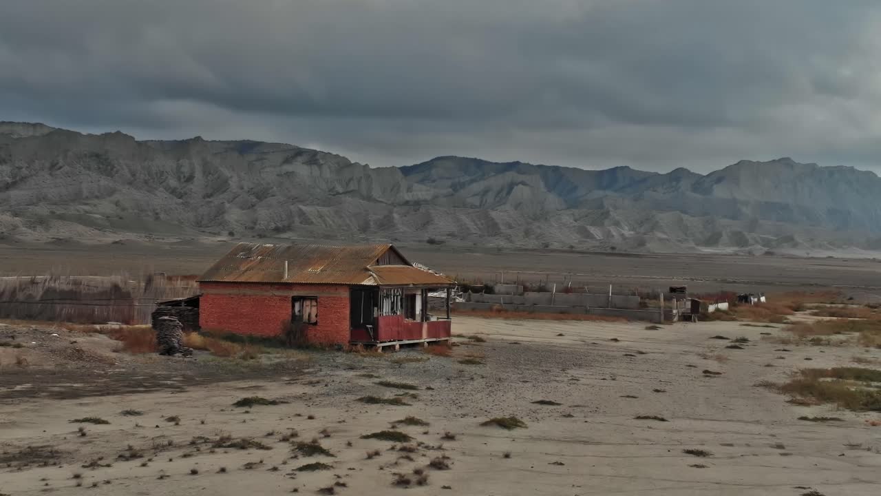 Utsikt over et forlatt hus i Georgia nær fjell under skyet himmel