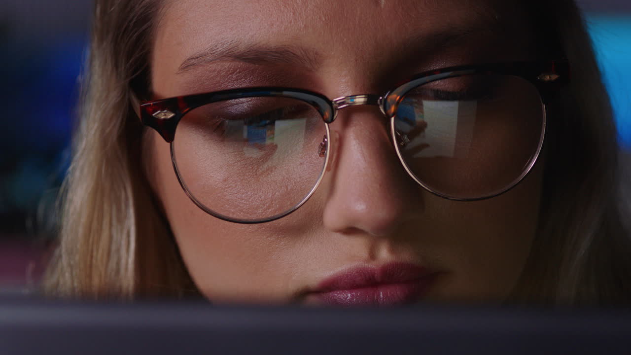 retrato en primer plano hermosa mujer de negocios caucásica trabajando hasta tarde usando una tableta navegando por datos de gráficos financieros mirando la información en la pantalla usando gafas