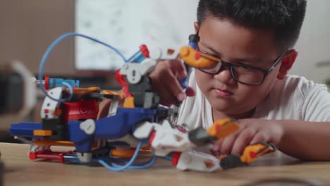 close up of asian cute boy repairing a cyborg hand at home