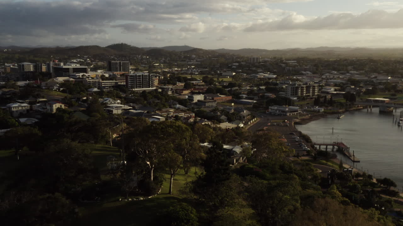 Aerial view of Gladstone Harbor City with rural mountain landscape at horizon during sunset,Australia