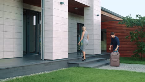 rich couple entering luxury apartments with luggage. happy family entering home