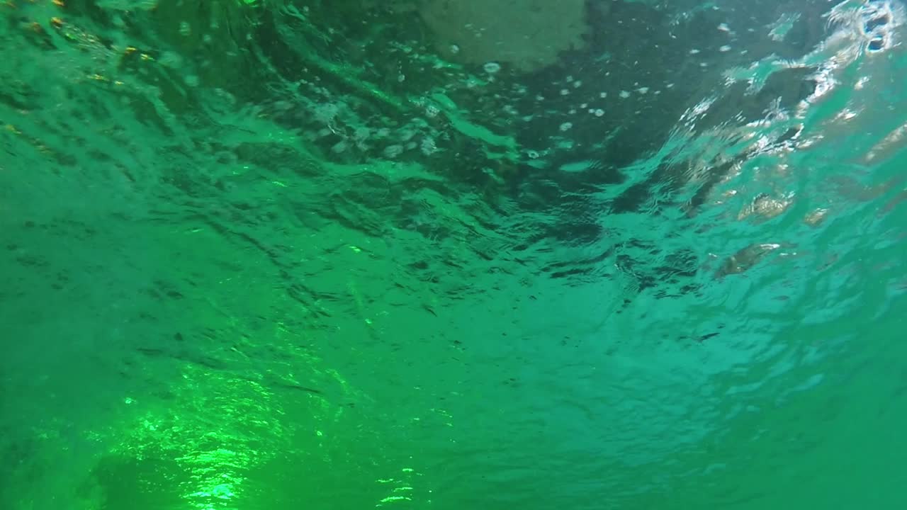 burbujas de aire ascendentes y superficie de agua ondulada