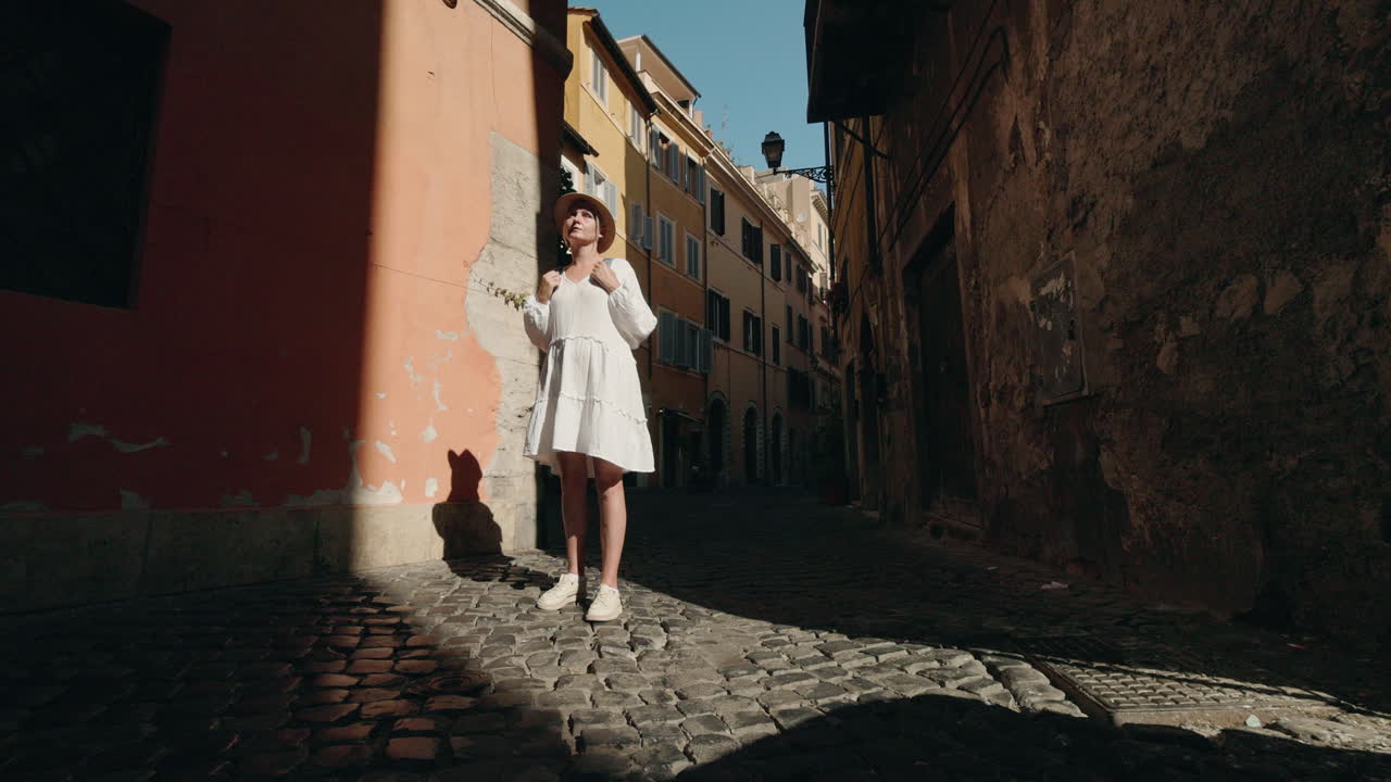 Woman in white dress on cobblestone street