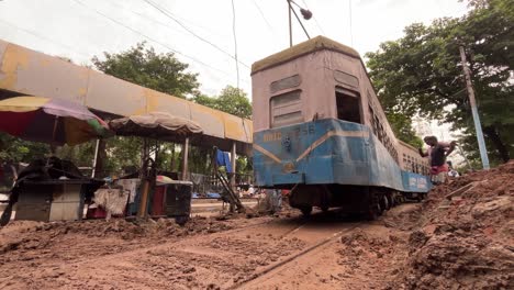 old tram stuck in mud on damaged road in kolkata, india