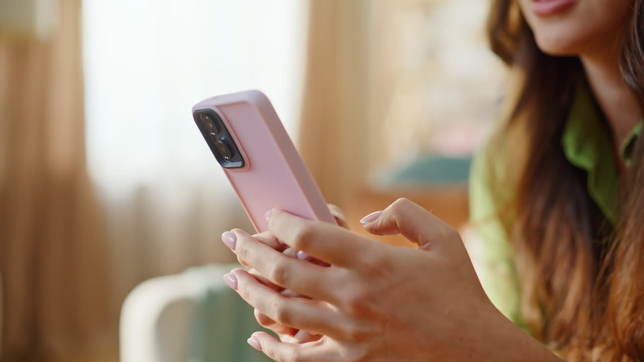 Primo piano di una donna che si rilassa a casa e manda messaggi con il cellulare. Brunetta che scrive messaggi
