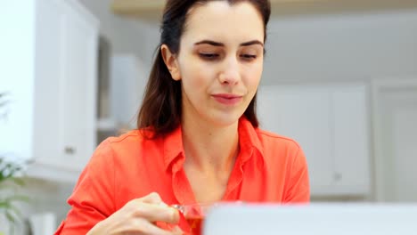 Woman-using-laptop-while-having-lemon-tea-4k