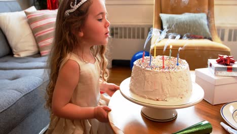 Niña-Soplando-Velas-En-El-Pastel-De-Cumpleaños