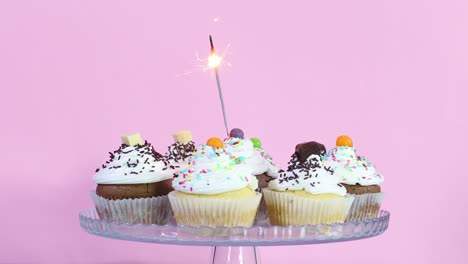 fire candle burning on cup cakes served on the plate for birthday party