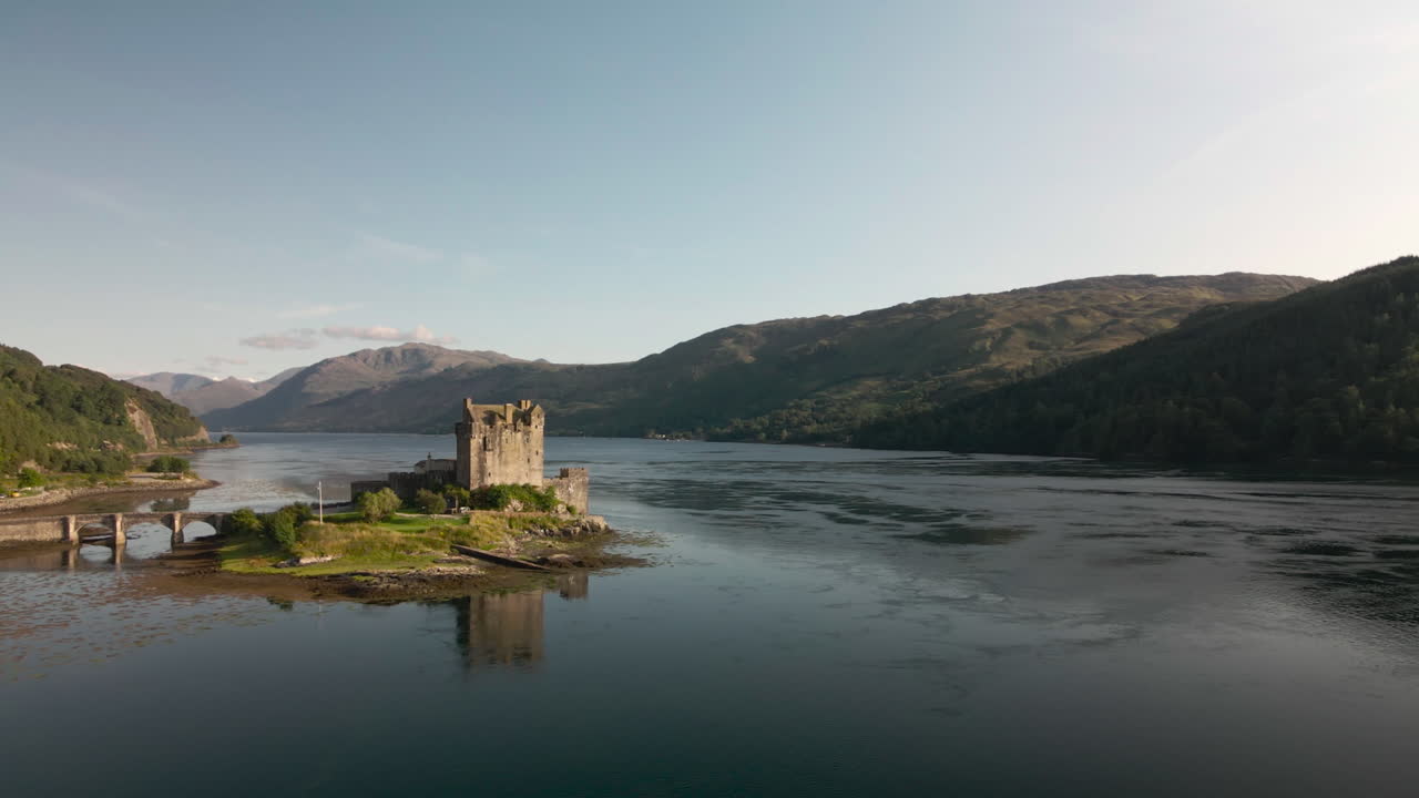 Forward ascending drone shot past Eilean Donon castle on clear summers day