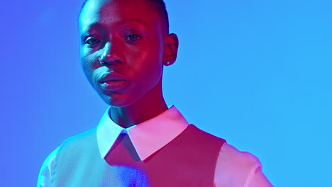 close-up of a beautiful black model as she turns to look into the camera with a serious intense expression on her face and then turns away