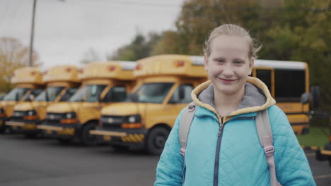 retrato de un estudiante feliz contra el fondo de un típico autobús escolar amarillo