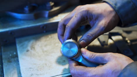 turner's hands adjusting metal piece to a detail. turner checking the compatibility of grinded details. close up.