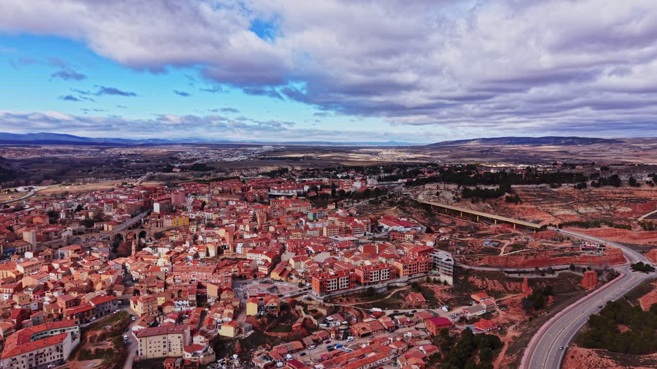 Udsigt over en by i Spanien med bygninger og veje under en skyet himmel