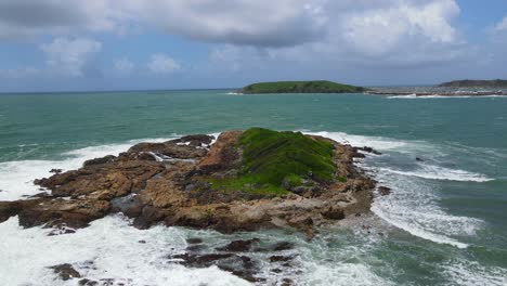 strong waves crashing on little muttonbird island with solitary islands marine park in background - coffs harbour, nsw, australia