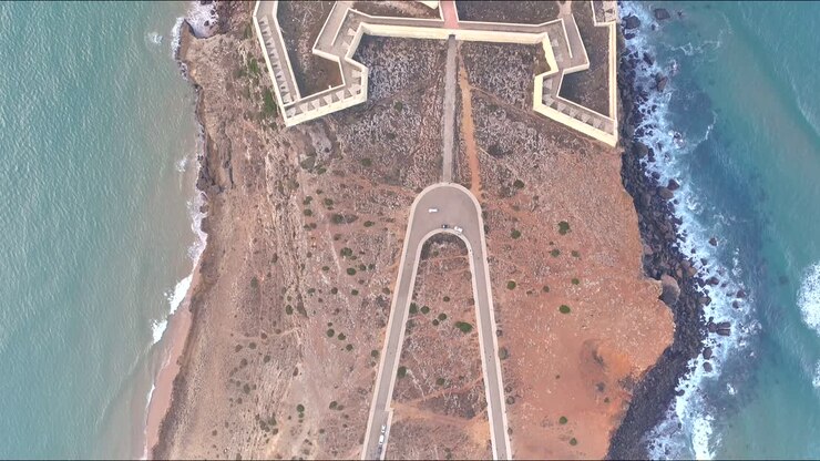 Birds eye view historical fort of Sagres at edge cliffs to the ocean Aerial Drone shot