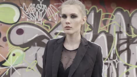 mujer elegante frente a una pared de graffiti