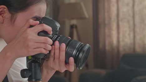 close up of asian female photographer taking photos of women's shoes in home studio