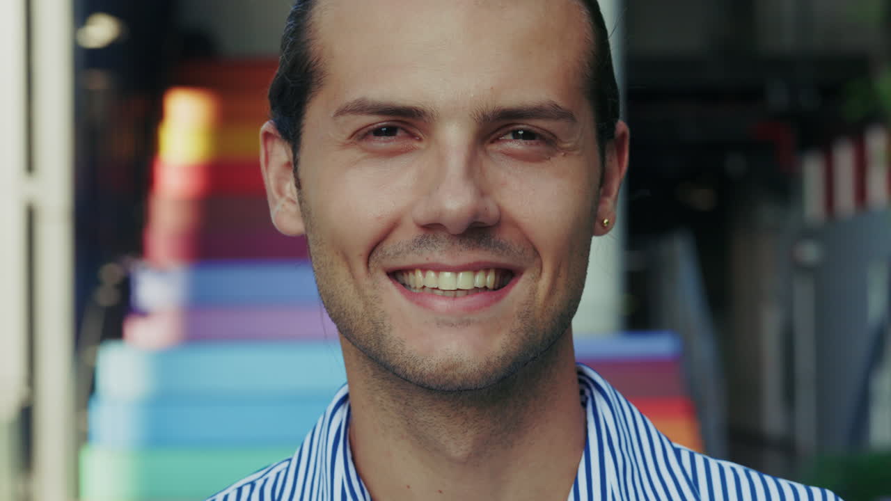 Close-up portrait of a smiling man with a colorful background
