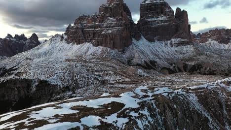 Aerial-view-revealing-the-Drei-Zinnen-mountains,-winter-dusk-in-Dolomites,-Italy