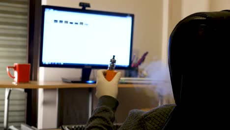 man browsing computer files with medical gloves and vaping