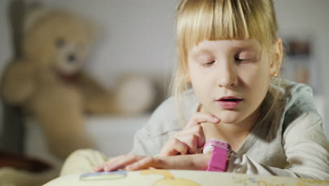 the child talks with the help of children's smart watches lying on the bed in my bedroom