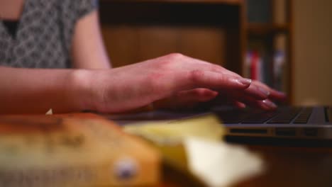 Woman-Types-on-laptop-computer-slow-motion-shiny-nails-office-setting-4K