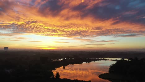 amanecer sobre un lago con paisaje urbano y nubes